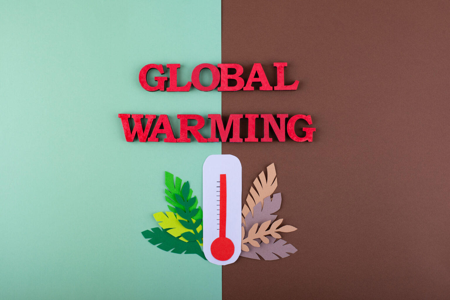 Schriftzug Global Warming auf grünem und braunem Hintergrund mit einem roten Thermometer in der Mitte