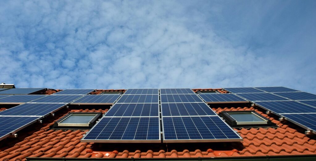 Ein Wohnhausdach mit neu installierten Solarmodulen während einer Sanierung, passend zum Thema Klimaförderung Antrag – Foto: ulleo / Pixabay