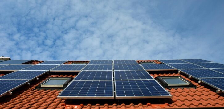 Ein Wohnhausdach mit neu installierten Solarmodulen während einer Sanierung, passend zum Thema Klimaförderung Antrag – Foto: ulleo / Pixabay